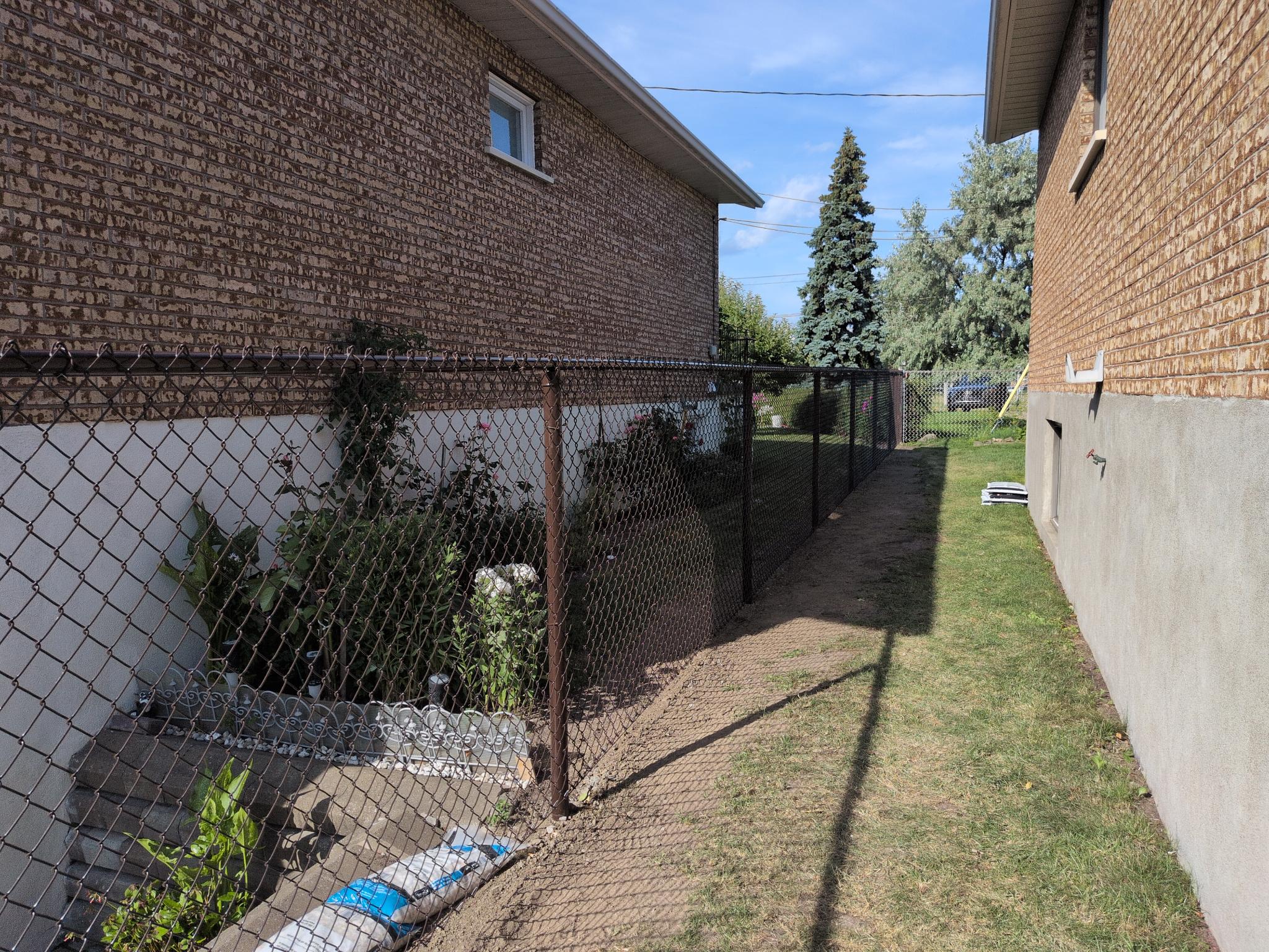 Black chain-link fence installed along a side yard